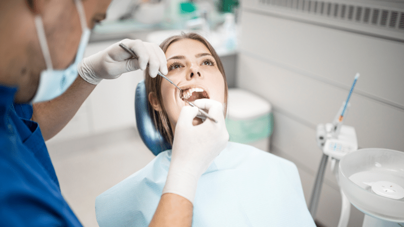 Photographie d'un endodontiste réalisant des soins sur un patient