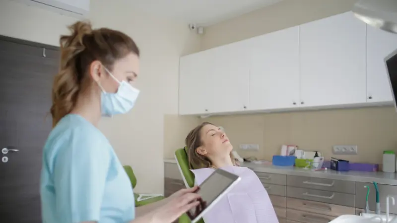 Assistante dentaire au cabinet avec une patiente